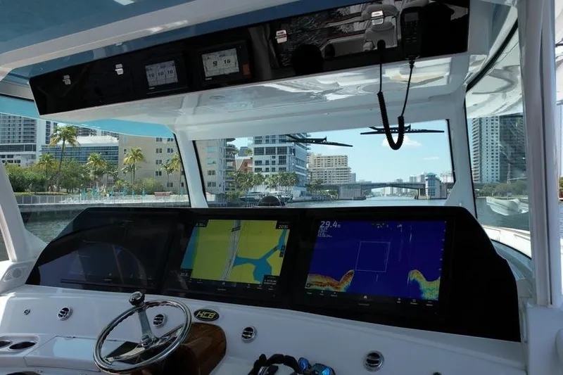 Slide: The Image of Helm of 2021 HCB 65 Estrella with navigation screens, steering wheel, and cityscape view. - 76