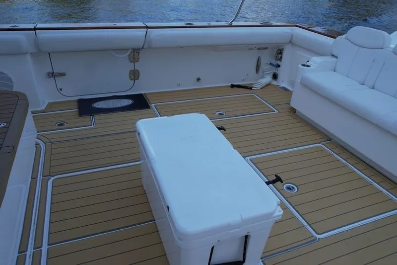 Slide: The Image of 2021 HCB 65 Estrella boat deck with white seating and cooler. - 84
