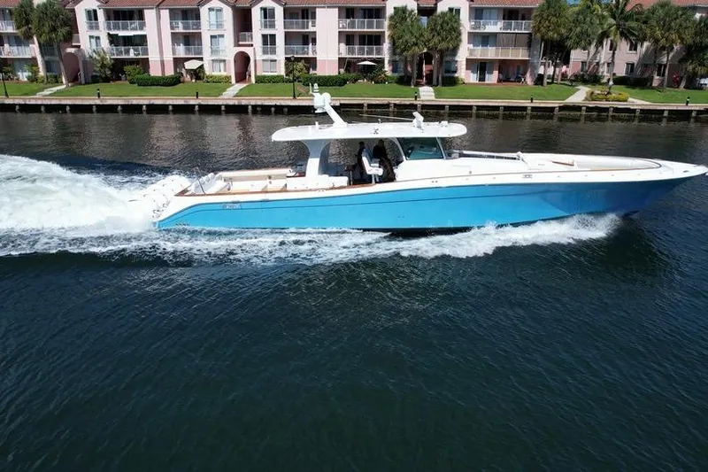 Slide: The Image of 2021 HCB 65 Estrella yacht cruising on a canal with waterfront homes in the background. - 97