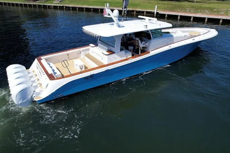 Slide: The Image of 2021 HCB 65 Estrella boat cruising on water, featuring sleek design and multiple outboard engines. - 99