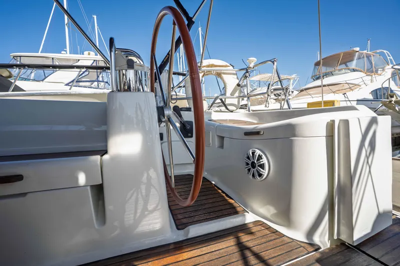 Slide: The Image of 2003 Jeanneau Sun Odyssey 45.2 yacht cockpit with wooden steering wheel and marina view. - 25
