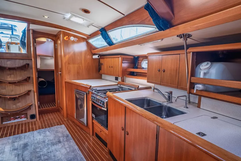Slide: The Image of Interior of 2003 Jeanneau Sun Odyssey 45.2 yacht, featuring a well-equipped kitchen area. - 48