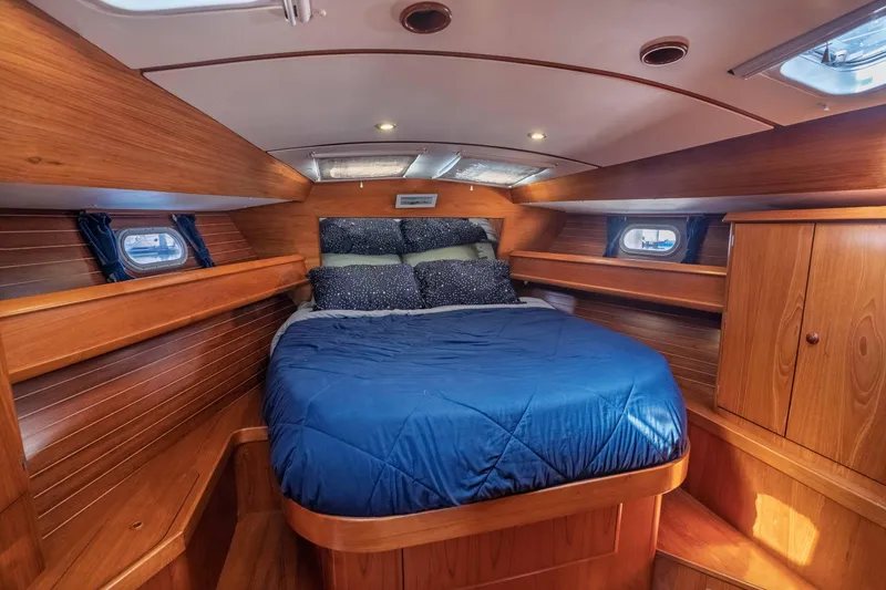 Slide: The Image of Cozy cabin interior of 2003 Jeanneau Sun Odyssey 45.2 with wooden finish and blue bedding. - 57