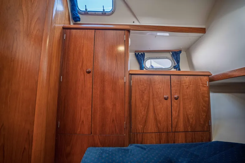 Slide: The Image of Interior cabin of 2003 Jeanneau Sun Odyssey 45.2 with wooden cabinetry and blue curtains. - 69