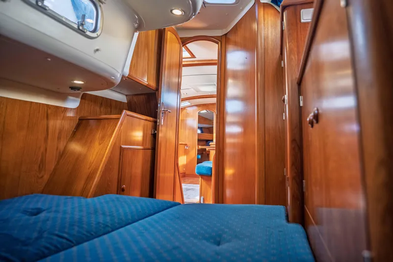Slide: The Image of Interior of 2003 Jeanneau Sun Odyssey 45.2 yacht with wooden finish and blue upholstery. - 70