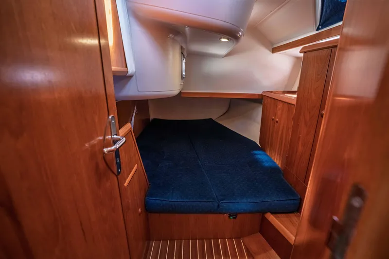 Slide: The Image of Cozy cabin interior of 2003 Jeanneau Sun Odyssey 45.2 with wooden finish and blue bedding. - 71