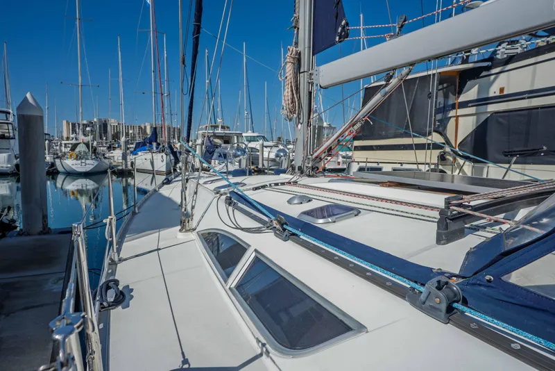 Slide: The Image of 2003 Jeanneau Sun Odyssey 45.2 sailboat docked in a marina, surrounded by other boats. - 9