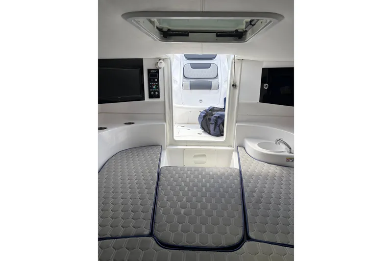 Slide: The Image of Interior of 2025 Glasstream 328 SCX boat, featuring modern seating and compact sink. - 12