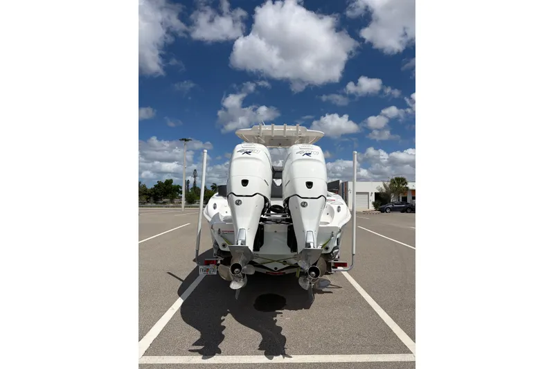 Slide: The Image of 2025 Glasstream 328 SCX boat with dual engines in a parking lot under a blue sky. - 13