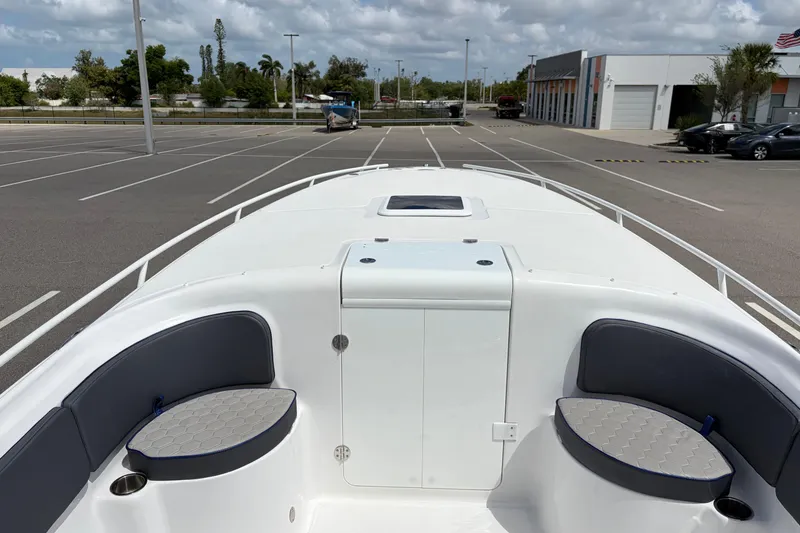 Slide: The Image of 2025 Glasstream 328 SCX boat interior with seating, parked in a lot under cloudy skies. - 29