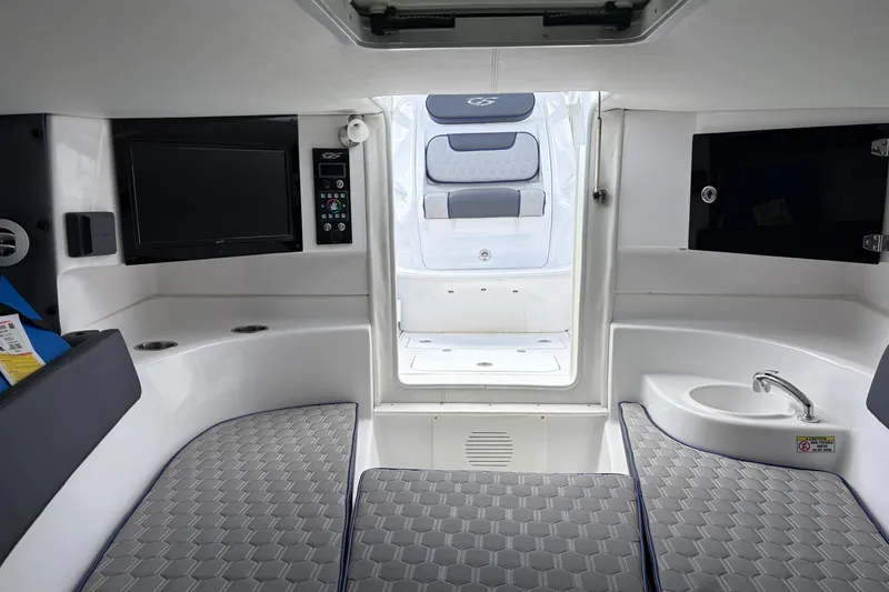 Slide: The Image of Interior of 2025 Glasstream 328 SCX boat, featuring seating, sink, and entertainment system. - 34