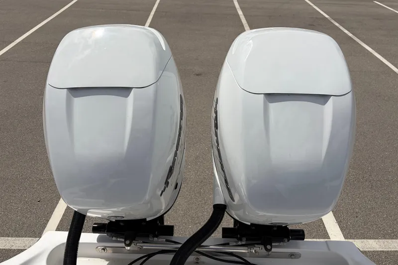 Slide: The Image of Twin outboard motors on a 2025 Glasstream 328 SCX boat in a parking lot. - 37