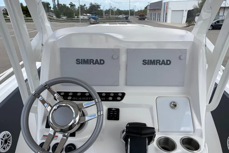 Slide: The Image of 2025 Glasstream 328 SCX boat dashboard with dual Simrad displays and steering wheel. - 38