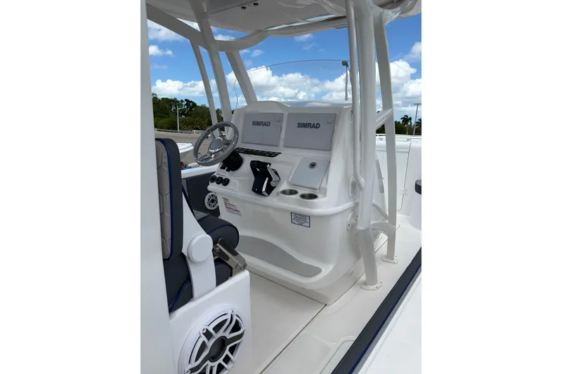 Slide: The Image of 2025 Glasstream 328 SCX boat cockpit with Simrad navigation system and steering wheel. - 8