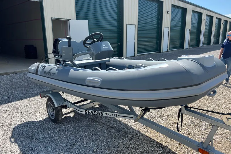 Slide: The Image of 2026 Highfield Classic 340 FCT boat on Genesis trailer, parked outside storage units. - 12