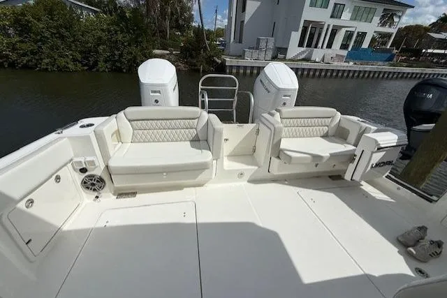 Slide: The Image of 2026 World Cat 400 DC-X Island boat with spacious seating and dual engines docked by a canal. - 14