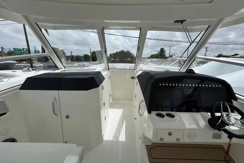 Slide: The Image of Interior view of 2026 World Cat 400 DC-X Island boat cockpit with steering wheel and controls. - 23