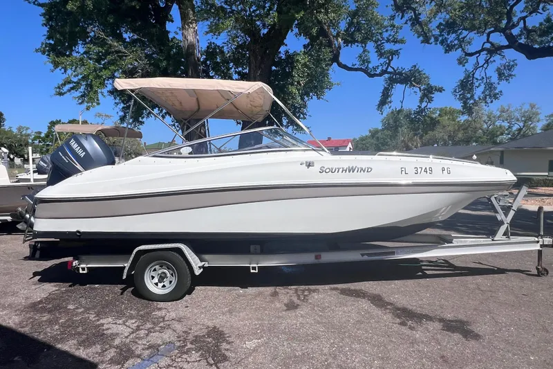 The Image of 2012 SouthWind 212 SD boat on trailer, parked outdoors under trees. - 0