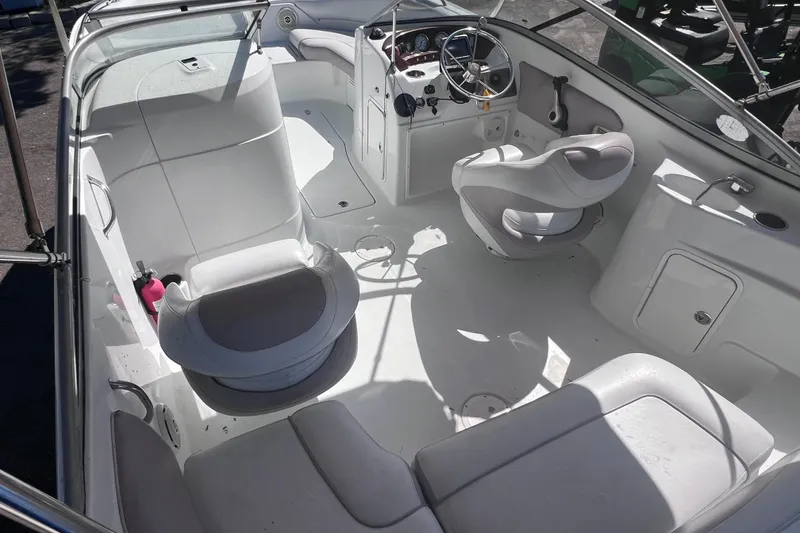 Slide: The Image of Interior of a 2012 SouthWind 212 SD boat, featuring white seating and steering console. - 10
