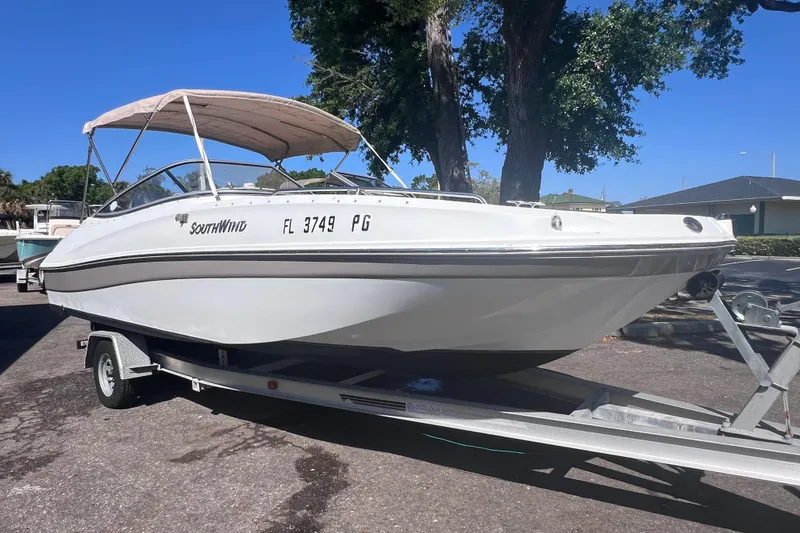Slide: The Image of 2012 SouthWind 212 SD boat on trailer, parked outdoors under trees. - 3