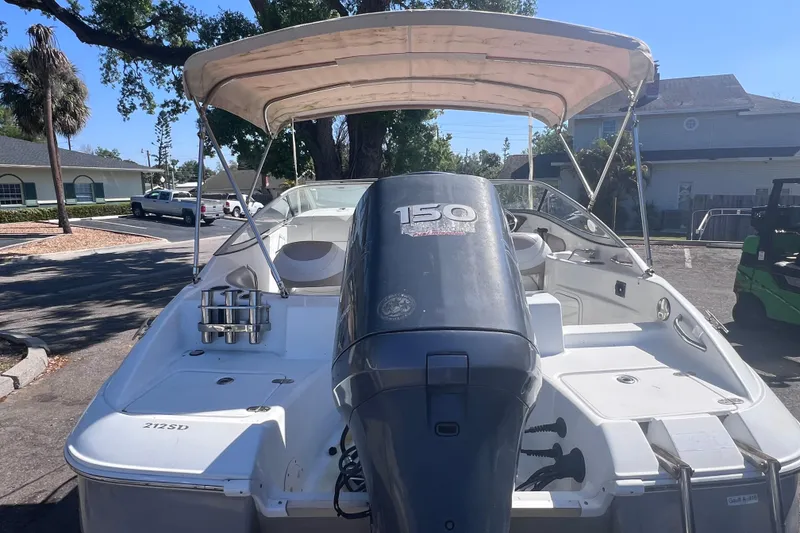 Slide: The Image of 2012 SouthWind 212 SD boat with outboard motor and canopy in a residential area. - 6