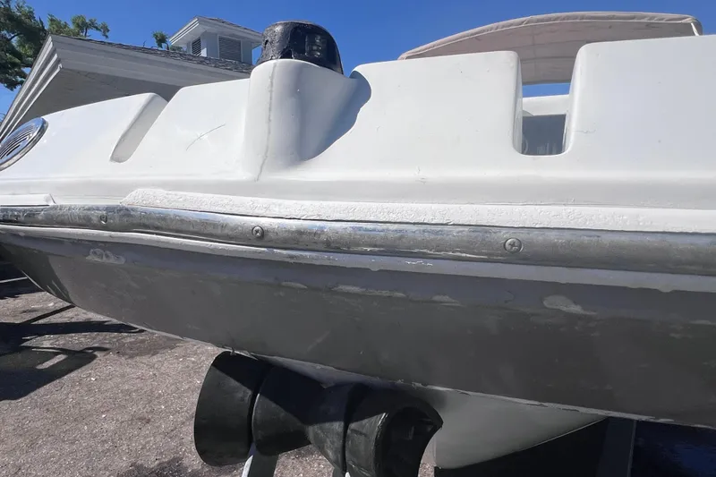 Slide: The Image of 2012 SouthWind 212 SD boat hull and propeller, parked outdoors under clear blue sky. - 8