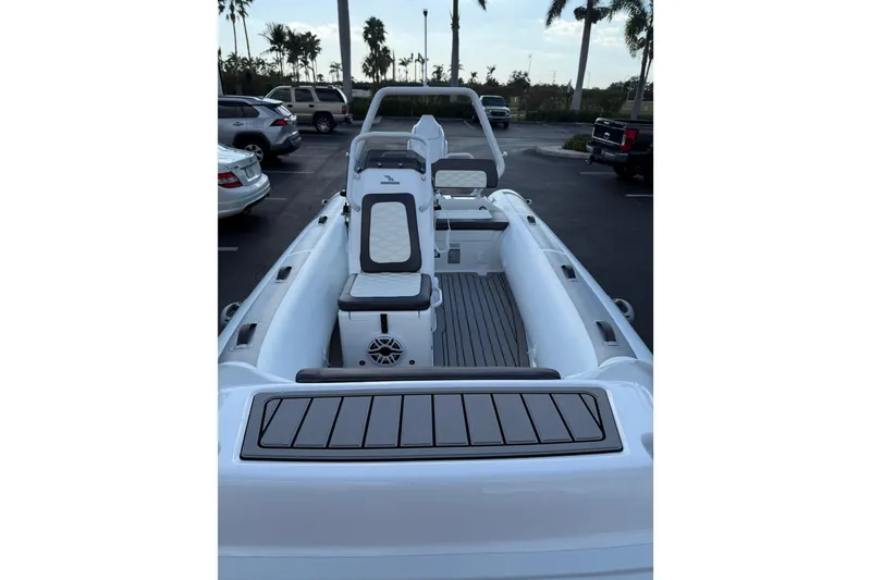 Slide: The Image of 2026 Highfield Sport 420 boat interior with seating and steering console in a parking lot. - 3