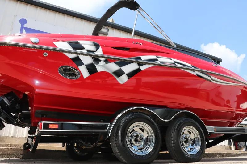 Slide: The Image of Red 2009 Crownline 23 SS boat with checkered flag design on trailer. - 10