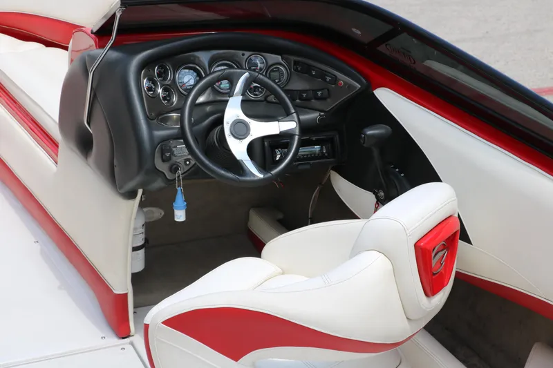 Slide: The Image of Interior of a 2009 Crownline 23 SS boat, featuring a sleek steering wheel and dashboard. - 16