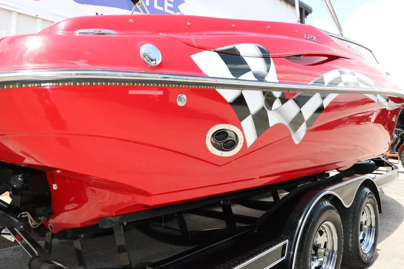Slide: The Image of Red 2009 Crownline 23 SS boat with checkered flag design on trailer. - 26