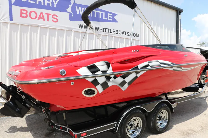 Slide: The Image of Red 2009 Crownline 23 SS boat with racing graphics on a trailer. - 3