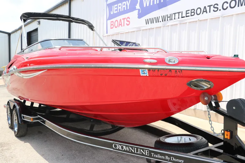 Slide: The Image of Red 2009 Crownline 23 SS boat on trailer, parked outside a building. - 5