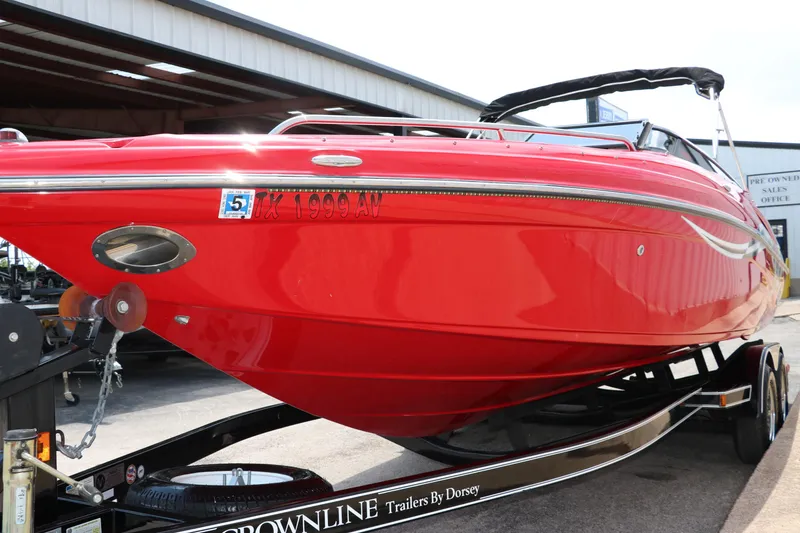 Slide: The Image of Red 2009 Crownline 23 SS boat on trailer, parked outside a building. - 7
