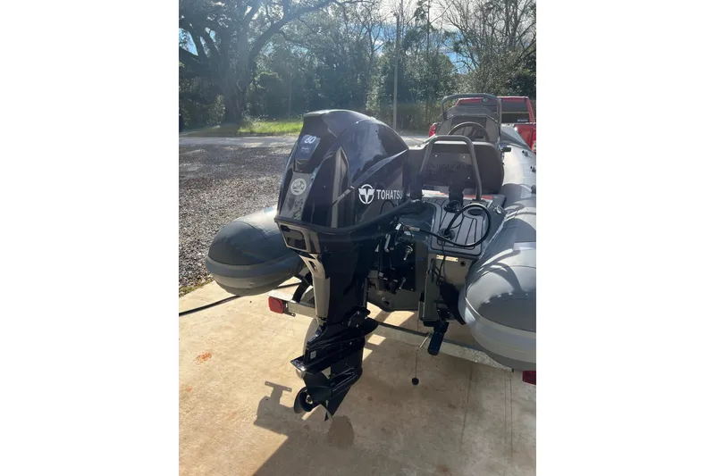 Slide: The Image of 2026 Highfield Sport 390 boat with Tohatsu outboard motor in a sunny outdoor setting. - 6