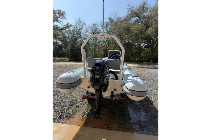 Slide: The Image of 2026 Highfield Classic 420 inflatable boat with outboard motor, parked on gravel. - 7