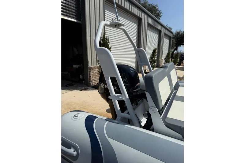 Slide: The Image of 2026 Highfield Classic 420 boat with Tohatsu engine, parked near a garage. - 8