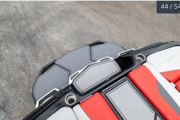 Slide: The Image of 2019 MasterCraft XStar boat interior with red and gray seating and cup holders. - 12