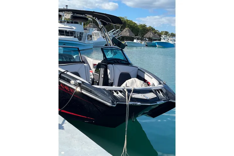 Slide: The Image of 2019 MasterCraft XStar boat docked in a marina with clear blue water. - 17