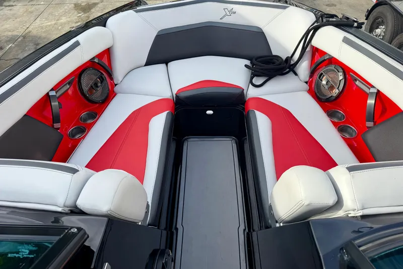 Slide: The Image of 2019 MasterCraft XStar boat interior with red and white seating, cup holders, and speakers. - 4