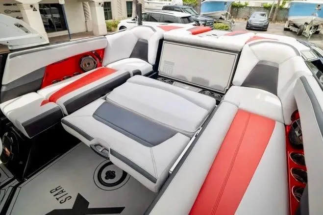 Slide: The Image of 2019 MasterCraft XStar boat interior with red and gray seating, showcasing luxury and comfort. - 7