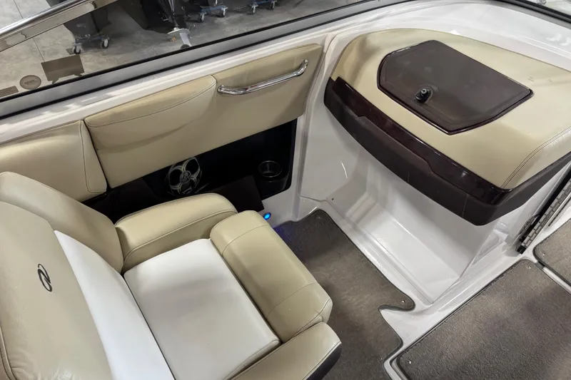 Slide: The Image of 2015 Regal 2700 Bowrider interior with beige seating and storage compartment. - 9