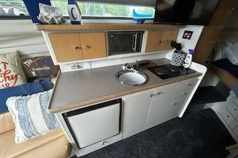 Slide: The Image of 1994 Carver 310 Santego boat interior kitchen with sink, microwave, and mini-fridge. - 6