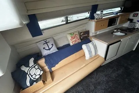 Slide: The Image of 1994 Carver 310 Santego interior with cozy seating, nautical decor, and compact kitchenette. - 7