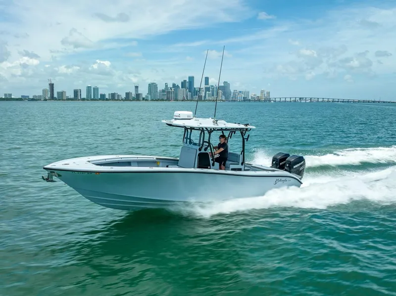Slide: The Image of 2021 Yellowfin 29 Offshore boat cruising on water with city skyline. - 1