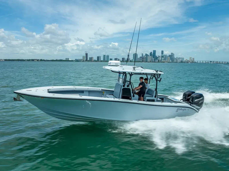 Slide: The Image of 2021 Yellowfin 29 Offshore boat cruising on water with city skyline. - 17