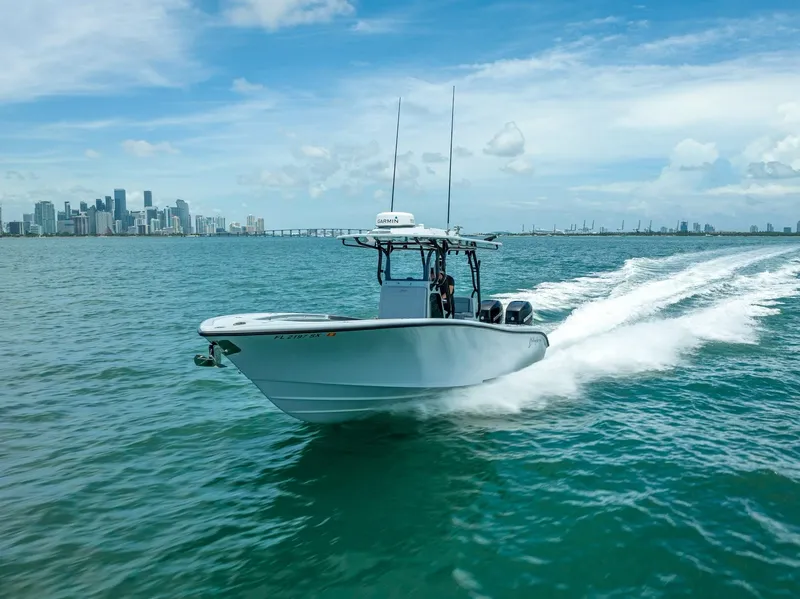 Slide: The Image of 2021 Yellowfin 29 Offshore boat cruising on water with city skyline. - 19