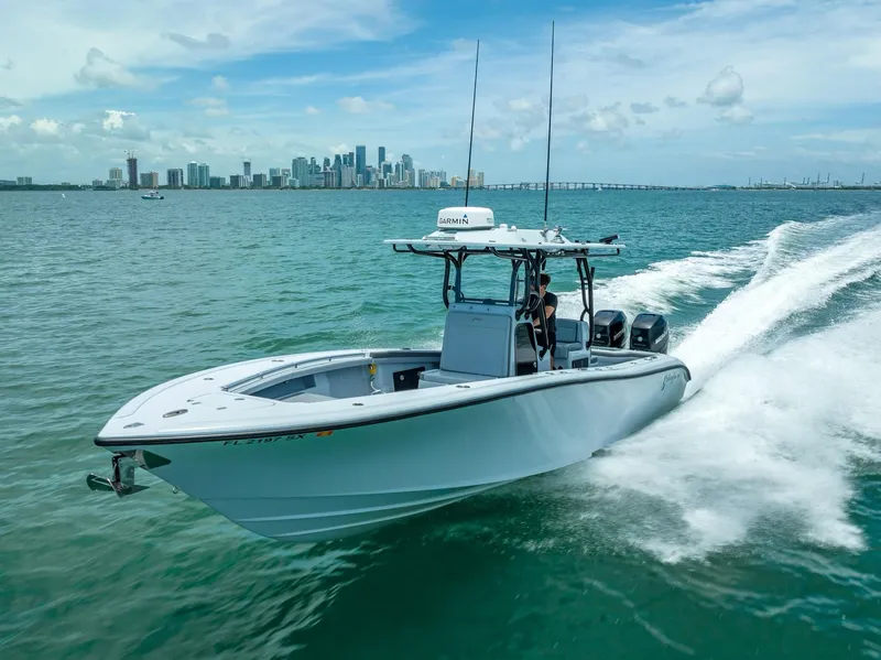 Slide: The Image of 2021 Yellowfin 29 Offshore boat cruising on water near a city skyline. - 21