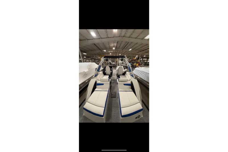 Slide: The Image of 2026 South Bay 25 Sport Twin boat interior with luxurious seating in a showroom. - 11