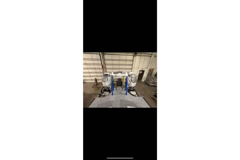 Slide: The Image of 2026 South Bay 25 Sport Twin boat engines in a warehouse setting. - 12