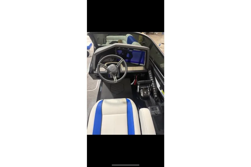 Slide: The Image of Interior view of 2026 South Bay 25 Sport Twin boat with modern steering and controls. - 21